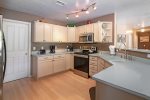 The kitchen is spacious with modern stainless steel appliances and plenty of workspace for entertaining